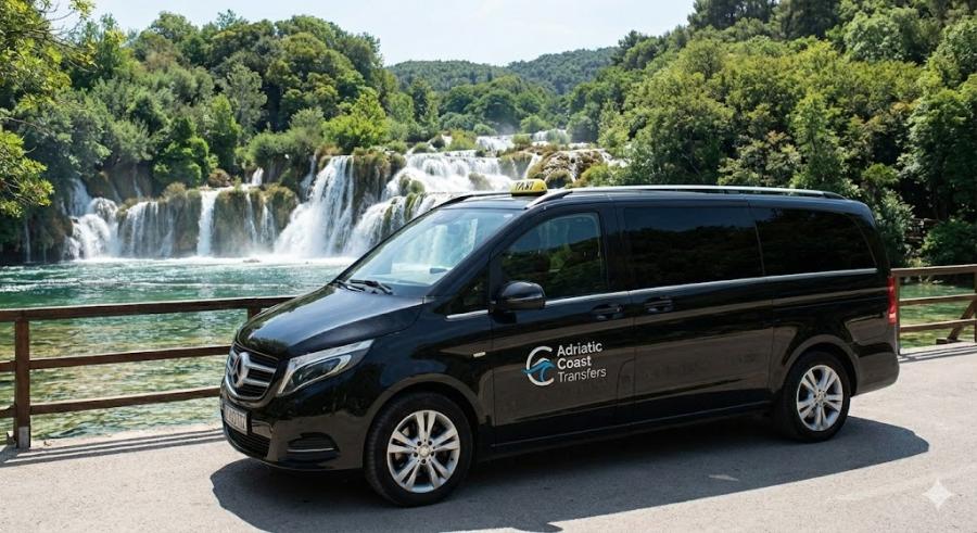 An Adriatic Coast Transfers taxi van parked in front of the stunning Skradinski Buk waterfalls at Krka National Park, representing private day trips from Zadar.